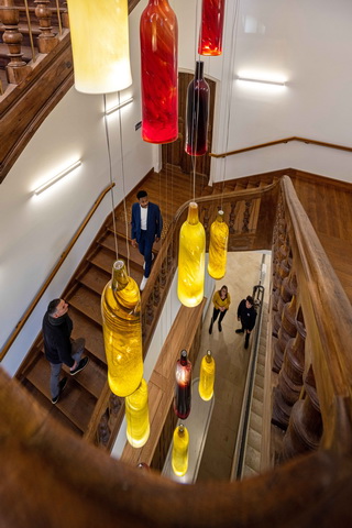 Un lustre monumental constitué de 24 grosses bouteilles